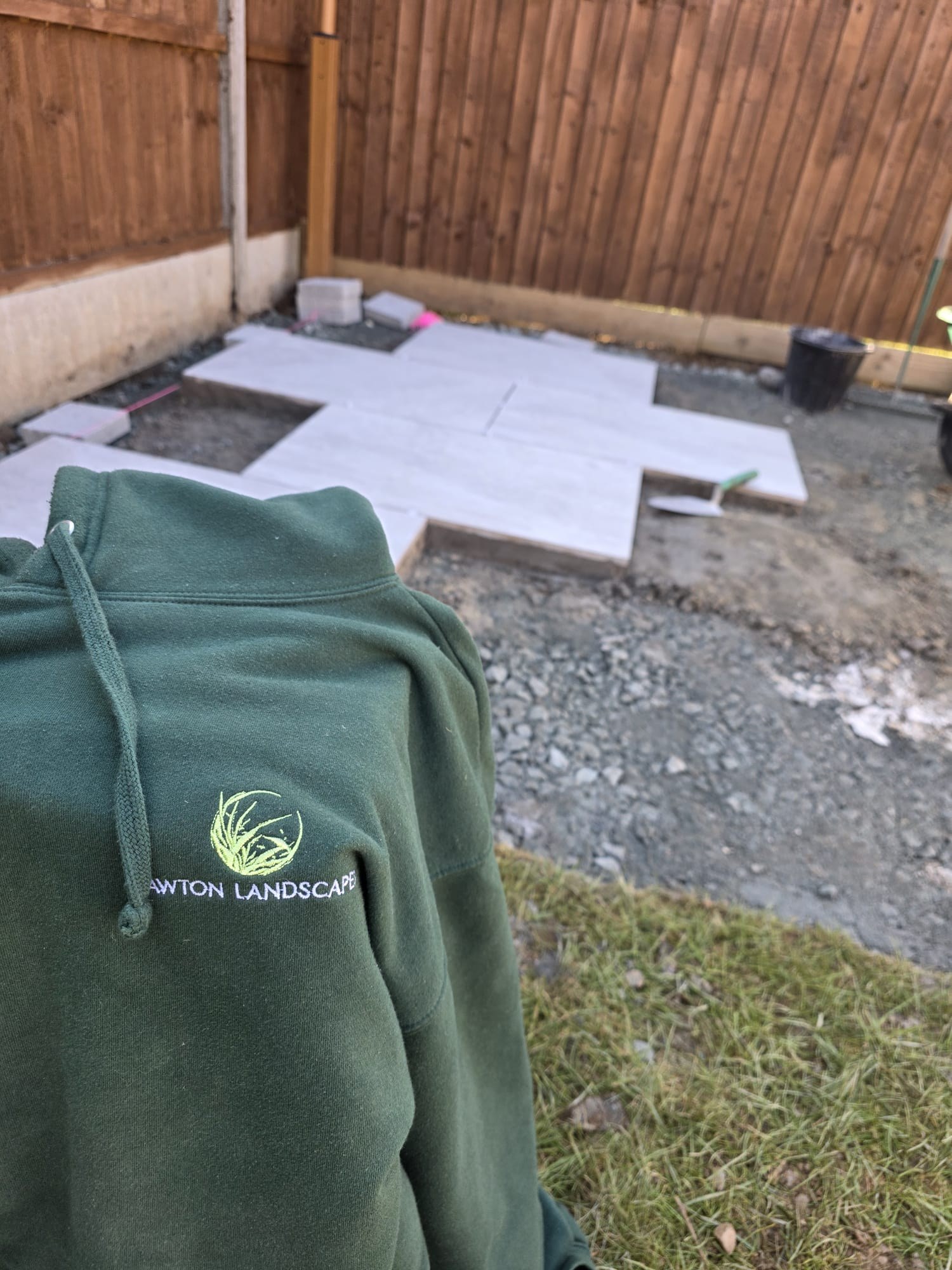 Porcelain patio slabs set out on a compacted base during a Lawton Landscapes patio installation