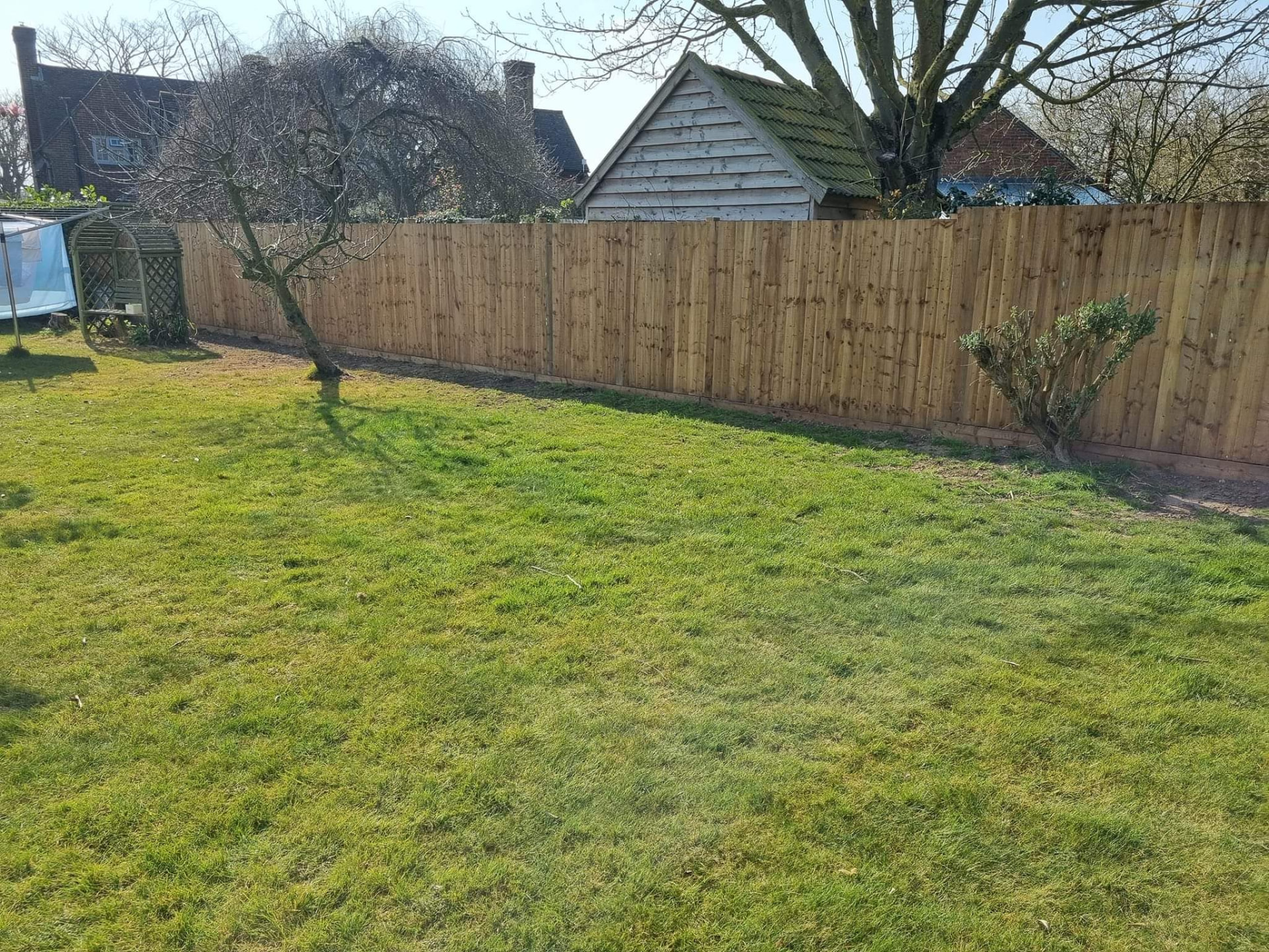 Straight run of new close-board fencing along a large garden boundary