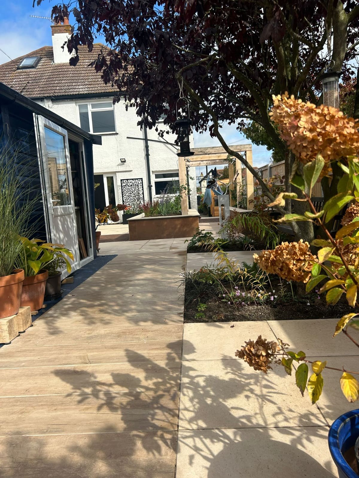 Stone paving and composite decking path combined in a landscaped garden