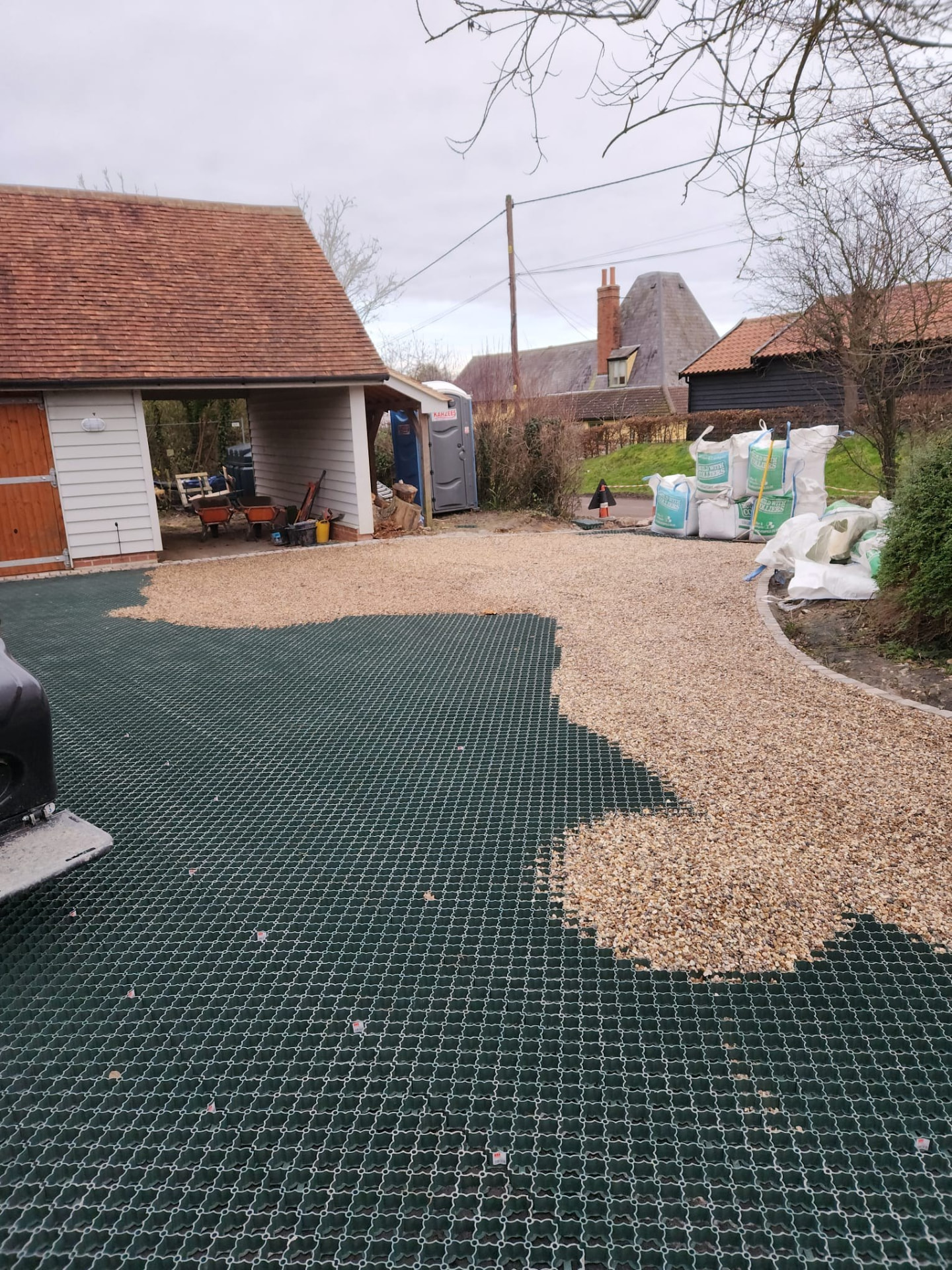 Plastic grass and gravel grid system being installed across a large driveway