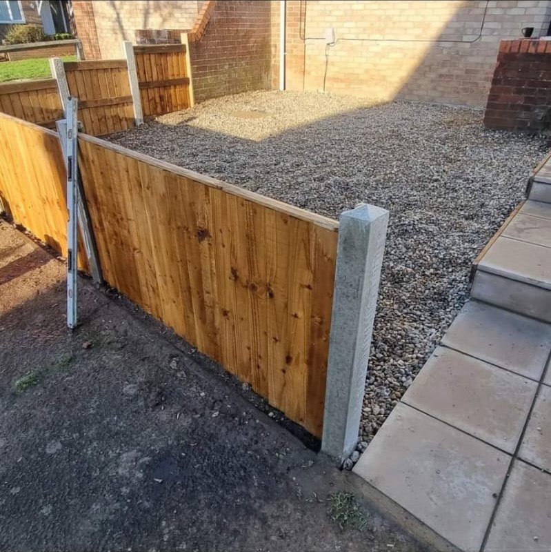 New close-board fence panel and concrete post set alongside a gravelled side area