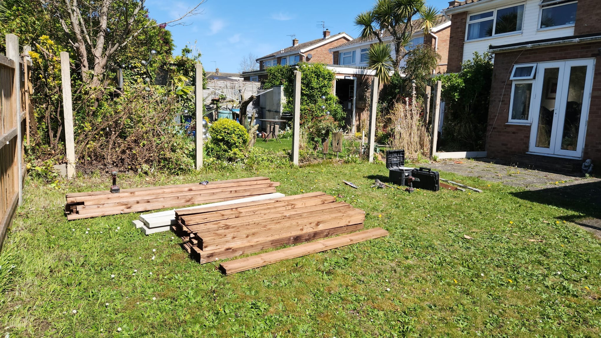 Timber fence boards and concrete posts stacked ready for installation